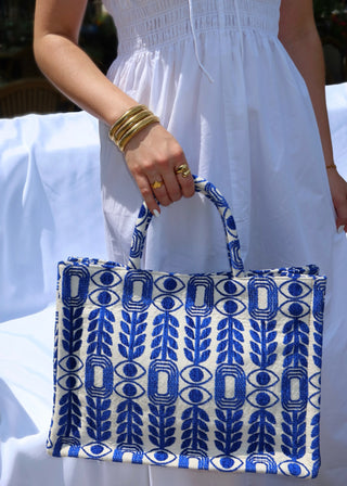 Large blue and white tote bag made in Greece by artisans using looms. Greek motif design with evil eyes, olive branches, and modern shapes. Handmade fashion shopper bag, beach bag