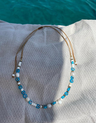 Blue evil eye bead and freshwater pearl adjustable necklace made in Greece. Handmade Greek jewelry at Aegean Essence