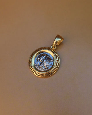 Silver replica ancient Greek coin featuring Athena, the Greek goddess of wisdom wearing a helmet, surrounded by an 18k gold-plated Greek key meander frame. Greek mythology jewelry