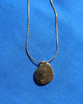 Back of gold pendant on necklace