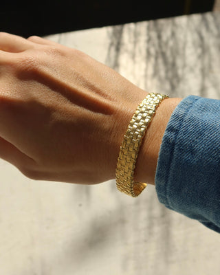 Gold basketweave cuff bracelet on a wrist, made in Greece. Greek handmade jewelry