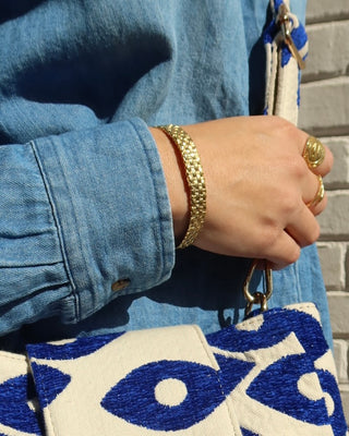 Gold basketweave cuff bracelet on a wrist, made in Greece. Greek handmade jewelry