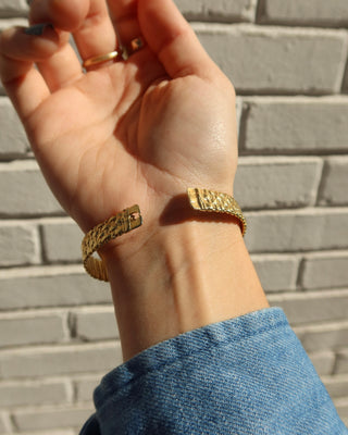 Gold basketweave cuff bracelet on a wrist, made in Greece. Greek handmade jewelry