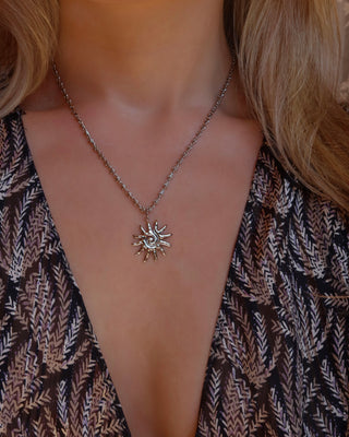 Woman wearing a silver spiral sun pendant necklace made in Greece, Greek jewelry