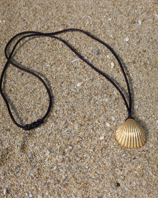 Black silky cord necklace with a gold-plated shell pendant, made in Greece by Greek jewelry brand Zenais.