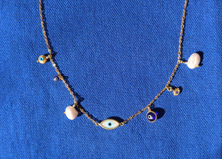 Gold plated evil eye necklace made in Greece with various evil eye charms and baroque freshwater pearls at Aegean Essence