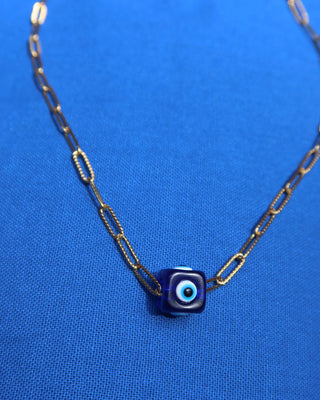 Necklace with a blue evil eye cube charm pendant on a gold paperclip chain made in Greece; Greek evil eye jewelry
