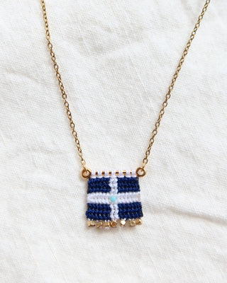 A woven macrame Greek flag necklace with a gold chain and gold bead details made in Greece. Vintage Hellenic Republic flag necklace with turquoise stone and gold embellishments