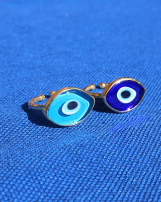 Two evil eye rings, one with a light blue Murano glass evil eye design and a gold band, and one with a dark blue Murano glass evil eye and gold band made in Greece; Greek evil eye jewelry rings