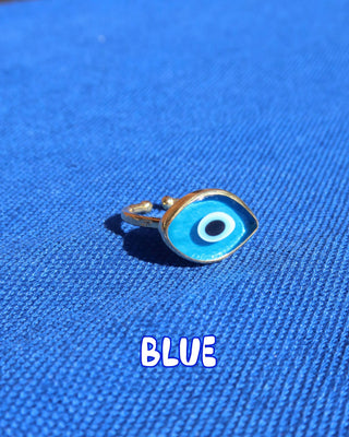 Light blue Murano glass evil eye ring with a gold band against a blue background, Greek evil eye jewelry