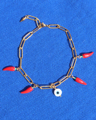 Gold paperclip chain bracelet with a white evil eye charm and red Italian cornicello charms for good luck, lucky charm bracelet made in Greece