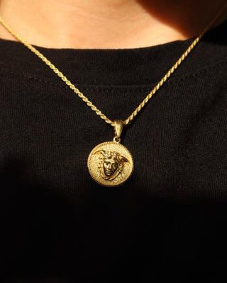 An 18k gold-plated sterling silver 925 rope chain necklace with a round medallion pendant featuring a Medusa design, worn by a person wearing a black shirt. Greek mythology jewelry