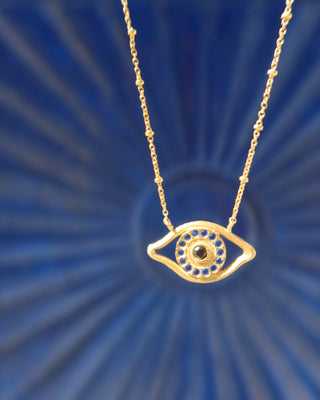 Gold plated necklace with an eye-shaped pendant on a person's neck - Greek evil eye jewelry made in Greece made with sterling silver 925 in the design of Homer's Odyssey eye on odysseus's ship