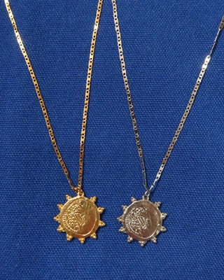 A gold sunburst ancient coin pendant necklace and a silver sunburst ancient coin pendant necklace made in Greece, greek jewelry