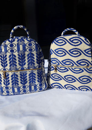 Woven cotton backpacks made in Greece with blue and white designs. Evil eye and olive leaf backpack, blue wave backpack handmade with gold zippers. Artisinal handbags handcrafted in Greece