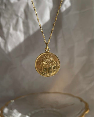 Gold coin necklace with date palm trees and a twisted gold chain by Greek jewelry designer Zenais at Aegean Essence