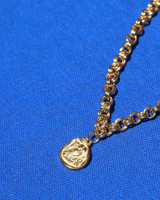 A gold statement necklace with a chunky chain and a gold tone Athenian tetradrachm replica Greek coin pendant with goddess Athena's owl of wisdom made in Greece