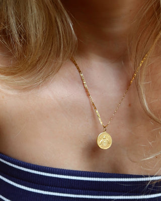 Model wearing a gold-plated ancient Greek bee coin pendant necklace made in Greece. Greek jewelry, Greek mythology
