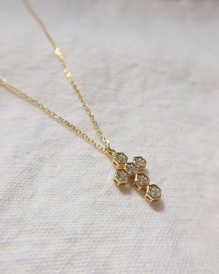 Gold-plated necklace with a cubic zirconia cross pendant on a woman's neck. Greek cross necklace, jewelry made in Greece