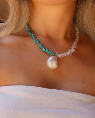 Woman wearing a turquoise and moonstone beaded necklace with a shell pendant made in Greece, summer beach jewelry