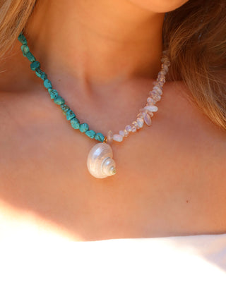 Woman wearing a turquoise and moonstone beaded necklace with a shell pendant made in Greece, summer beach jewelry
