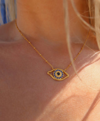 Gold plated necklace with an eye-shaped pendant on a person's neck - Greek evil eye jewelry made in Greece made with sterling silver 925 in the design of Homer's Odyssey eye on odysseus's ship