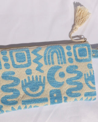 Woven cotton clutch bag wristlet with turquoise geometric print featuring evil eyes, rainbows, snakes, moons, and more made in Greece. Greek fashion accessory zipper pouch with tassel 